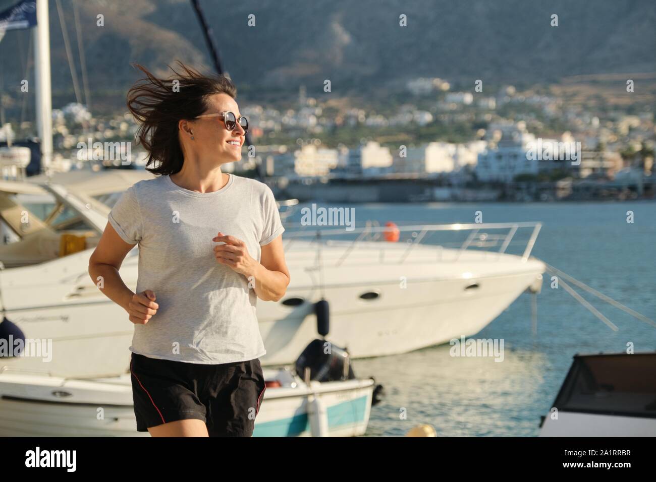 Smiling Sporty Mature Woman Jogging Running At Promenade Background