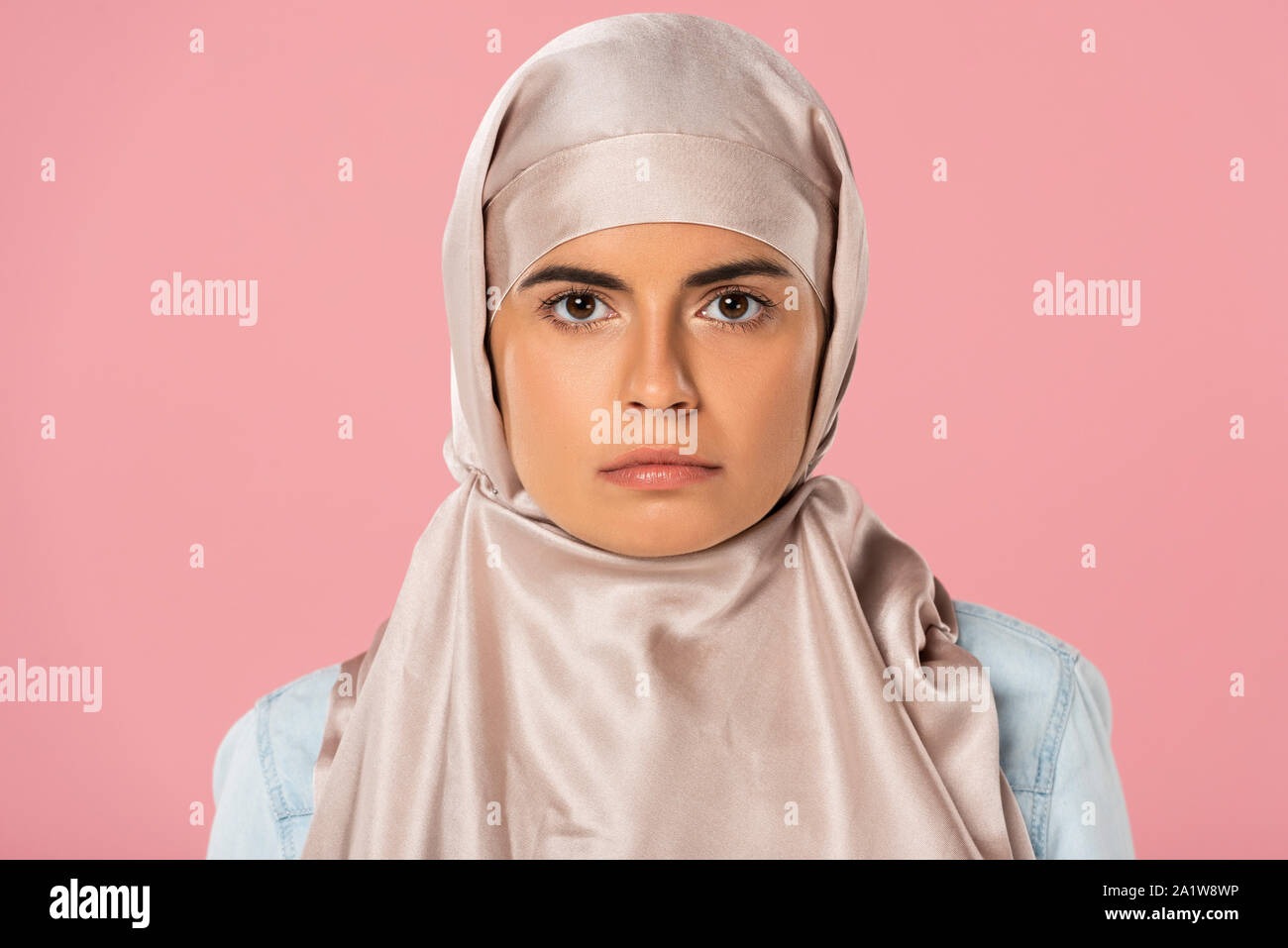 Beautiful Serious Muslim Girl In Hijab Isolated On Pink Stock Photo