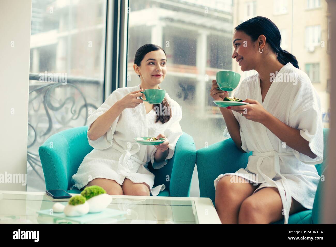 Two Friends Drinking Tea In The Beauty Salon And Smiling Stock Photo