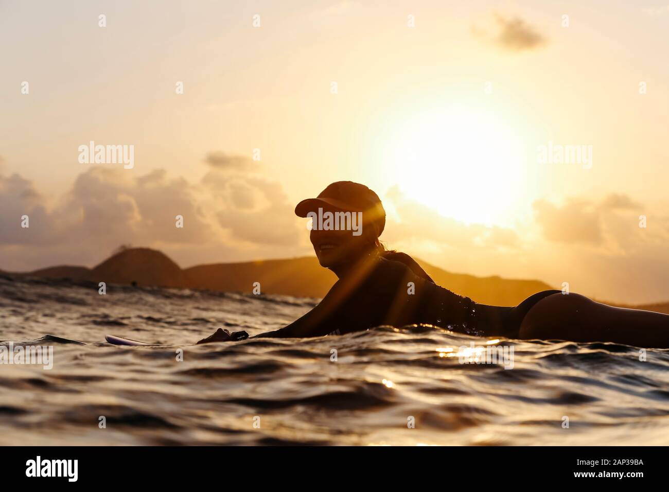 Female Surfer Lying On Surfboard In The Evening Stock Photo Alamy