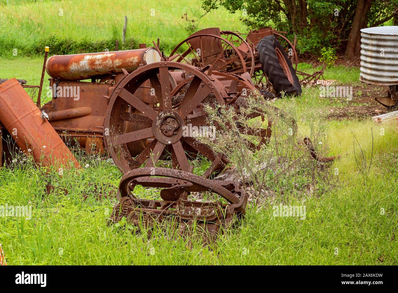 Old Rusted Farm Machinery From A Bygone Era Lying In An Overgrown Field