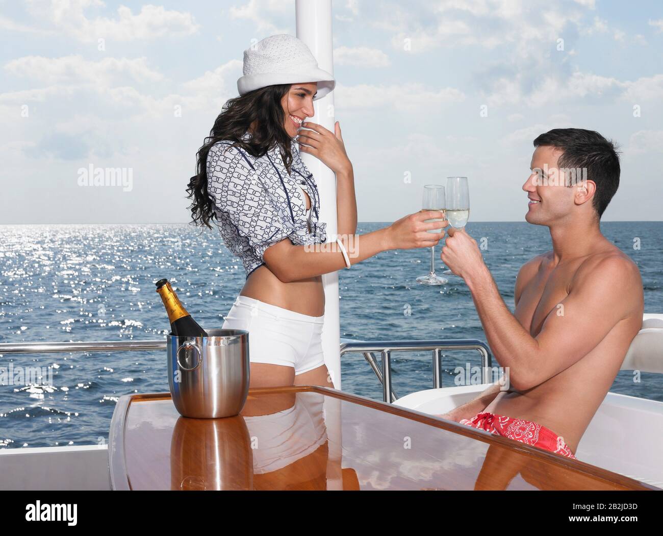 Жена пьет пиво катаясь на яхте в плавках