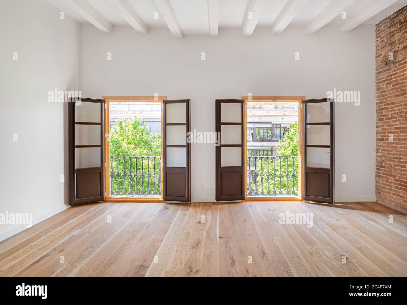 empty-and-clean-room-in-a-refurbished-flat-with-wooden-floor-and-two-balconies-real-estate-interior-2C4P7XM.jpg