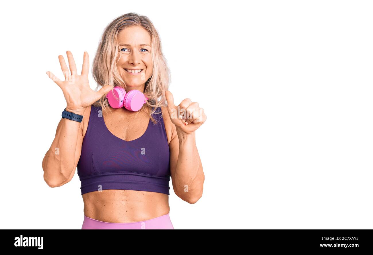 Middle Age Fit Blonde Woman Wearing Gym Clothes And Using Headphones