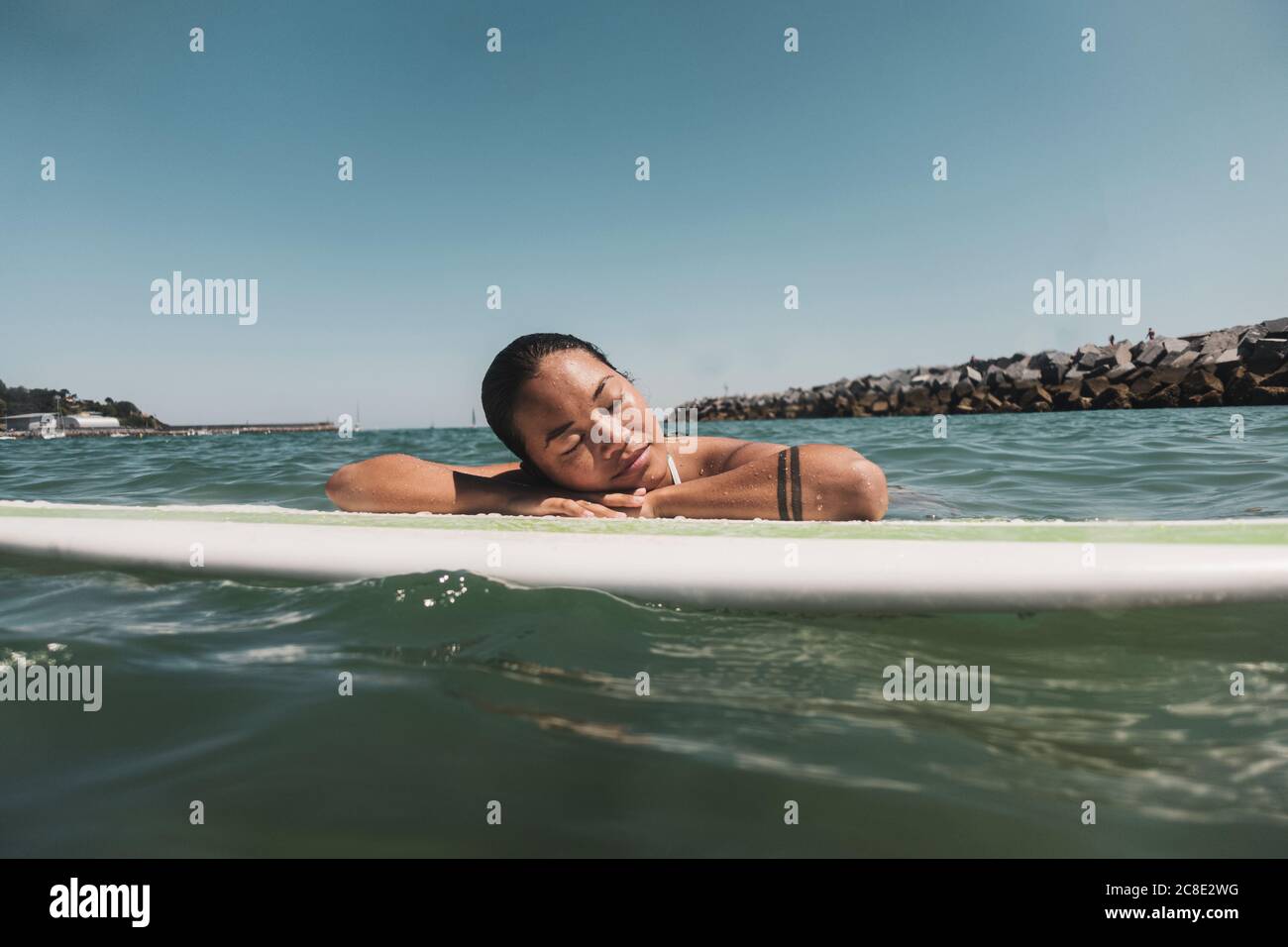 Female Surfer Lying On Surfboard Stock Photo Alamy