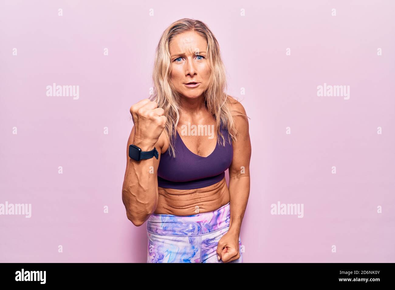 Middle Age Caucasian Blonde Woman Wearing Sportswear Over Pink