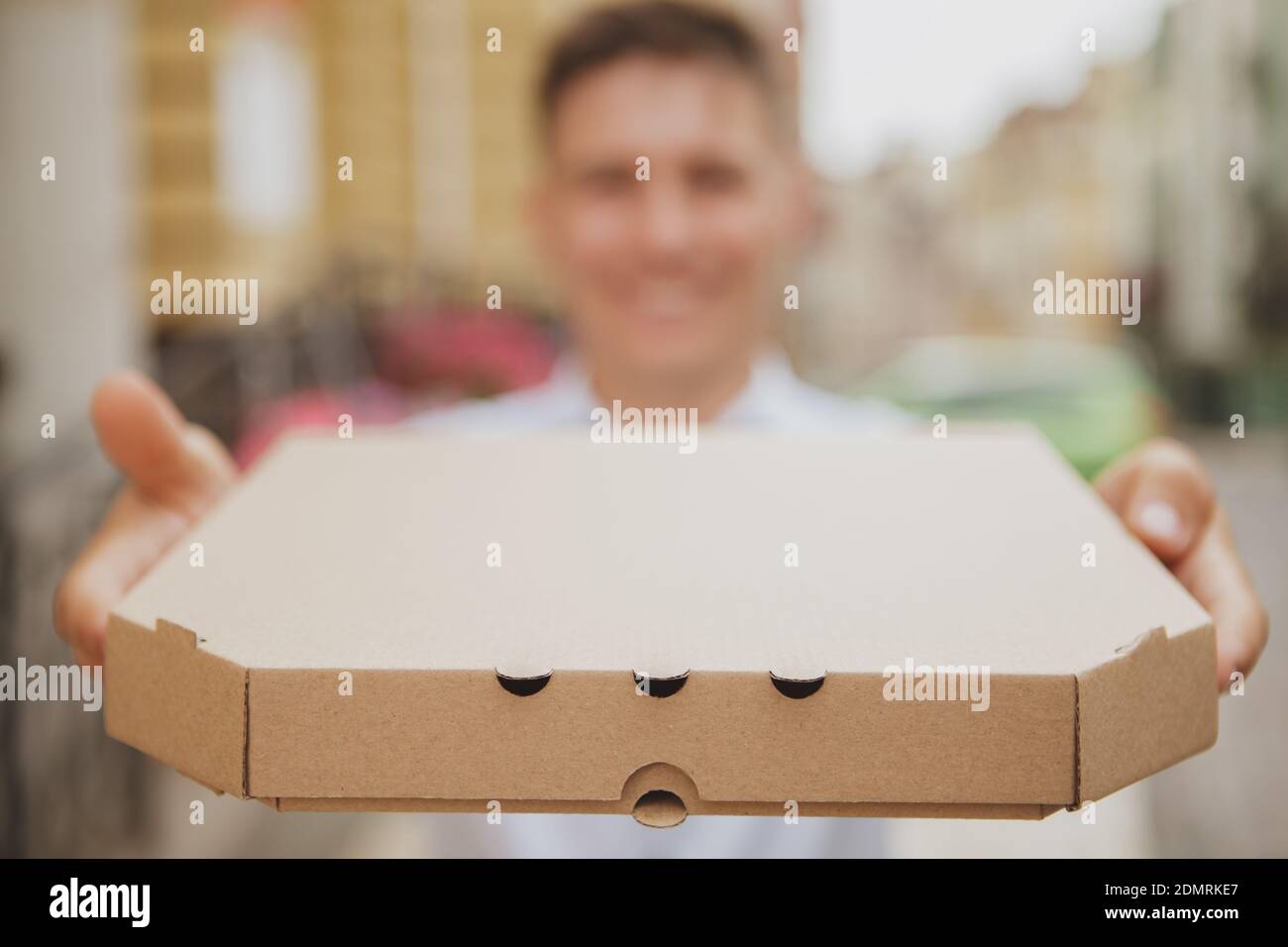 Happy Man Smiling Holding Out Pizza Box To The Camera Copy Space