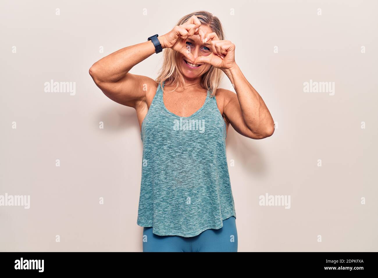 Middle Age Caucasian Blonde Woman Wearing Sportswear Doing Heart Shape