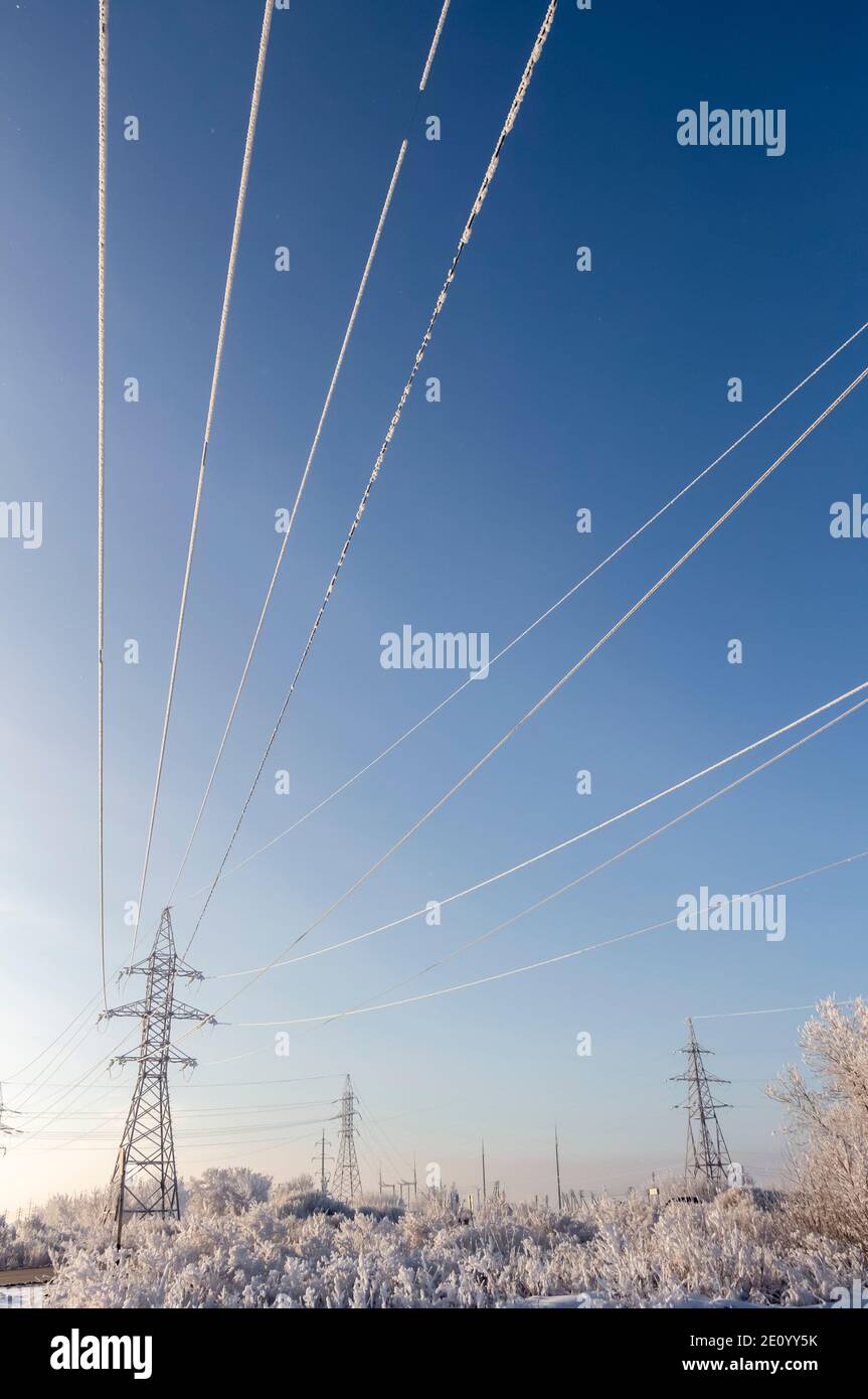 High Voltage Wires And Poles Are Covered With Frost On A Frosty Winter