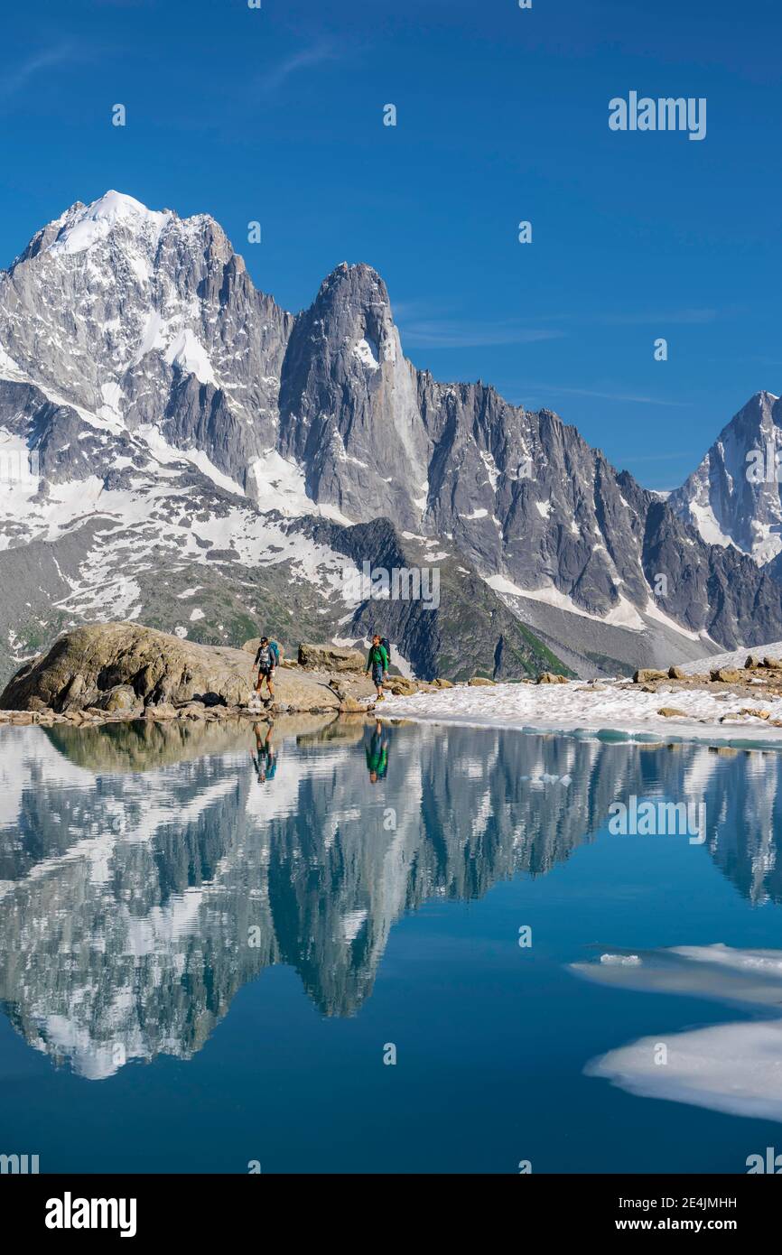 Two Hikers In Front Of Mountain Panorama Ice Floe On Lac Blanc