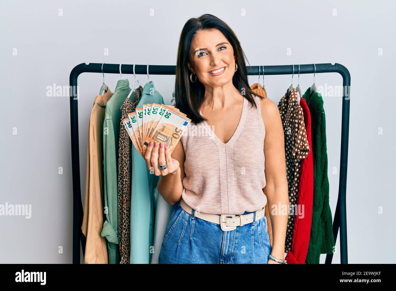 Middle Age Brunette Personal Shopper Woman Holding 50 Euros Banknotes