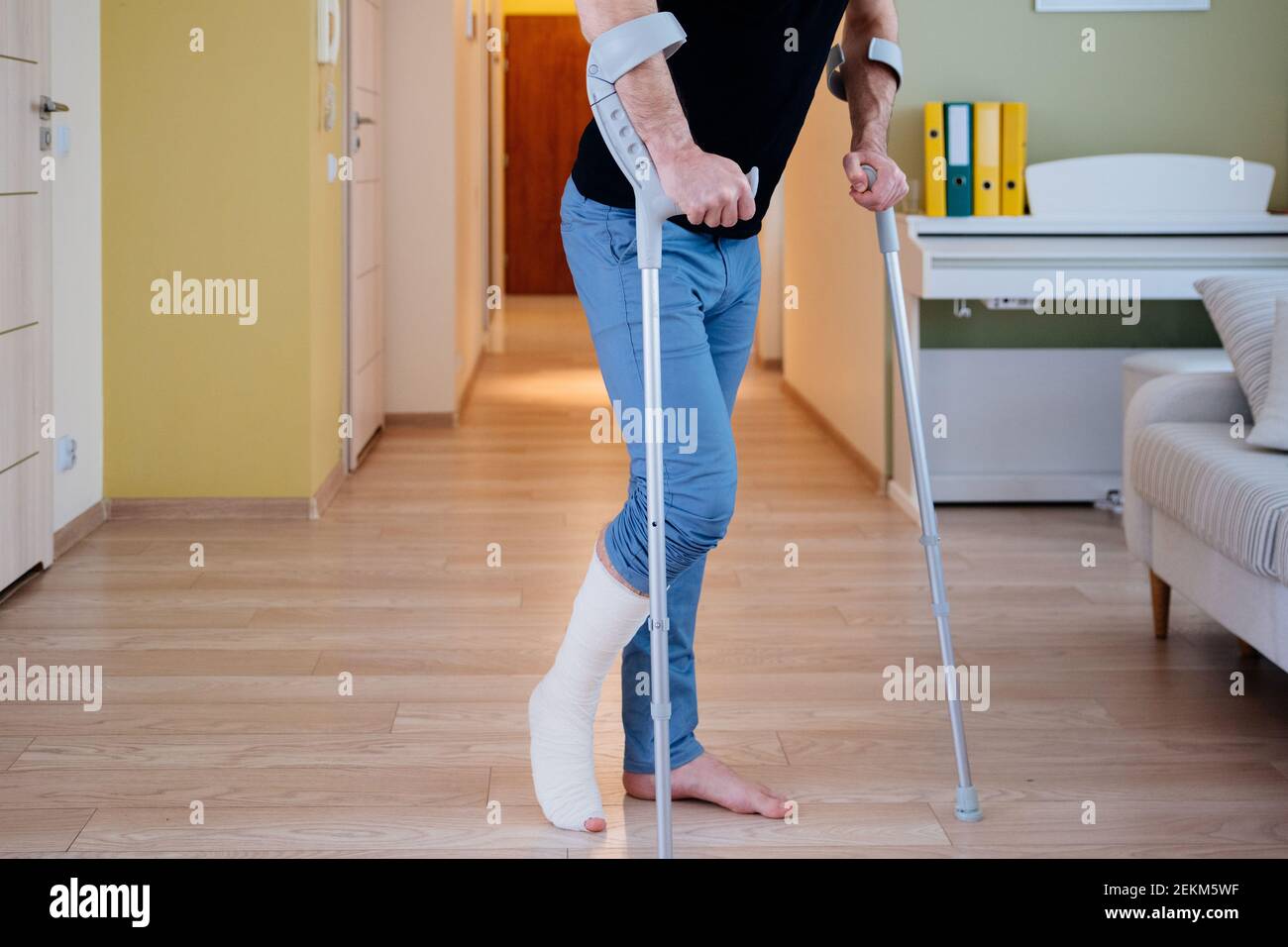 Injured Man Trying To Walk On Crutches Rehabilitation Of A Broken Leg