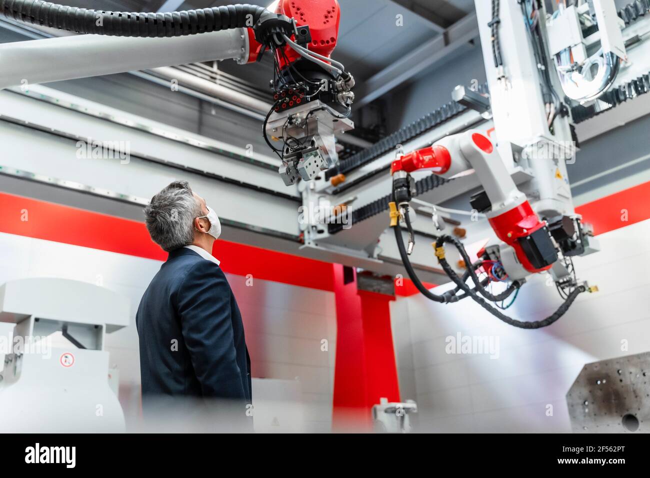 Mature Automation Engineer With Protective Face Mask Examining Robotics