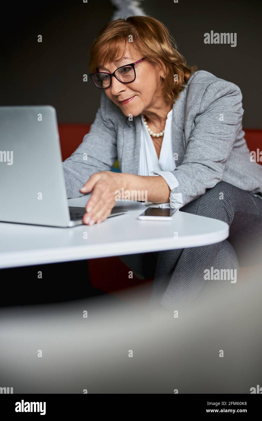 Positive Delighted Mature Woman Having Video Conversation Stock Photo