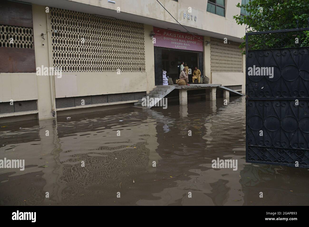 Pakistani Commuters Wade Through A Flooded Street After Heavy Monsoon