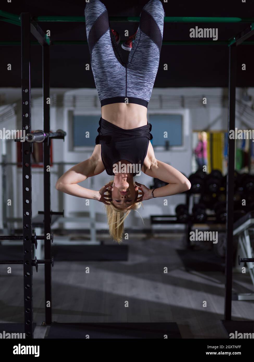 Athlete Woman Doing Abs Exercises Hanging Upside Down On Horizontal Bar At Gym Stock Photo Alamy