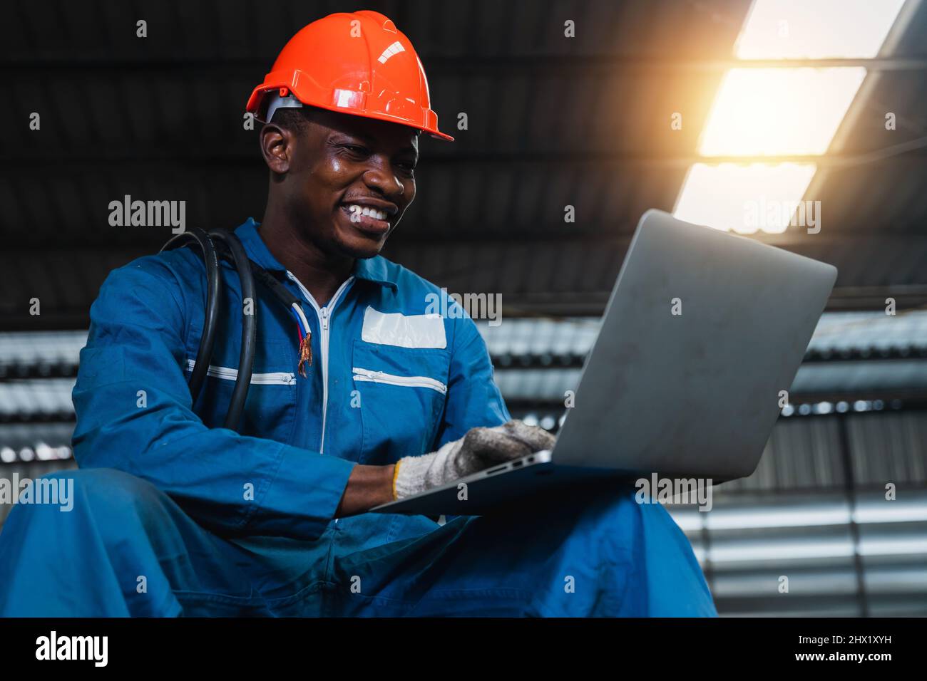 Happy African Electrical Engineer Man Working On Laptop By Checking And