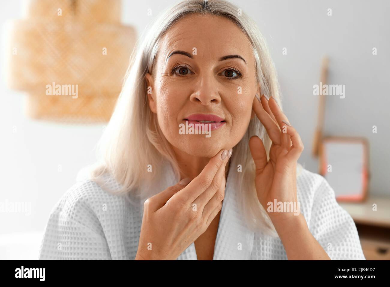 Morning Of Mature Woman Giving Herself Facial Massage At Home Stock Photo Alamy