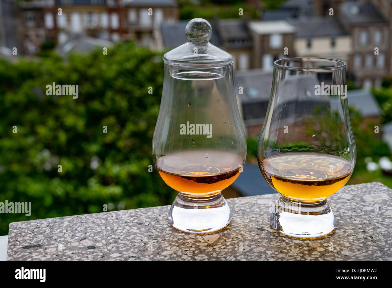 Two Drams Of Scotch Whiskey With View On Old Houses On Background