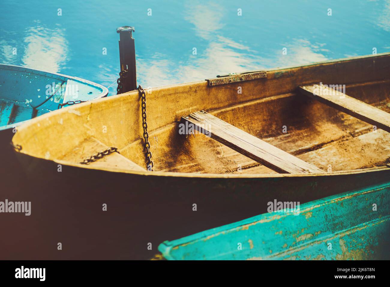 Old Blue Fishing Boats Float Near The Shore On The Surface Of The River