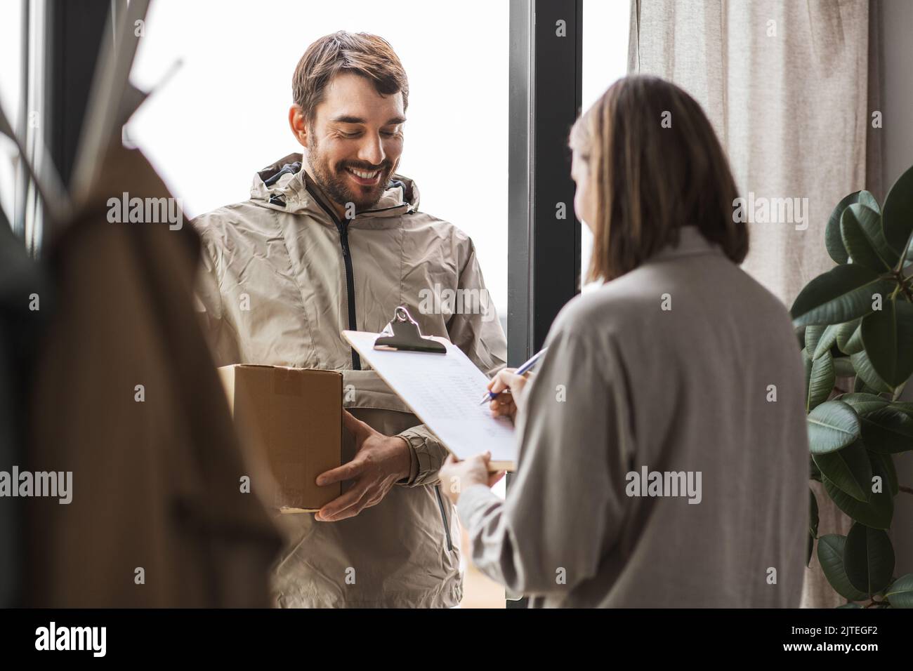 Delivery Man With Parcel Box And Customer At Home Stock Photo Alamy