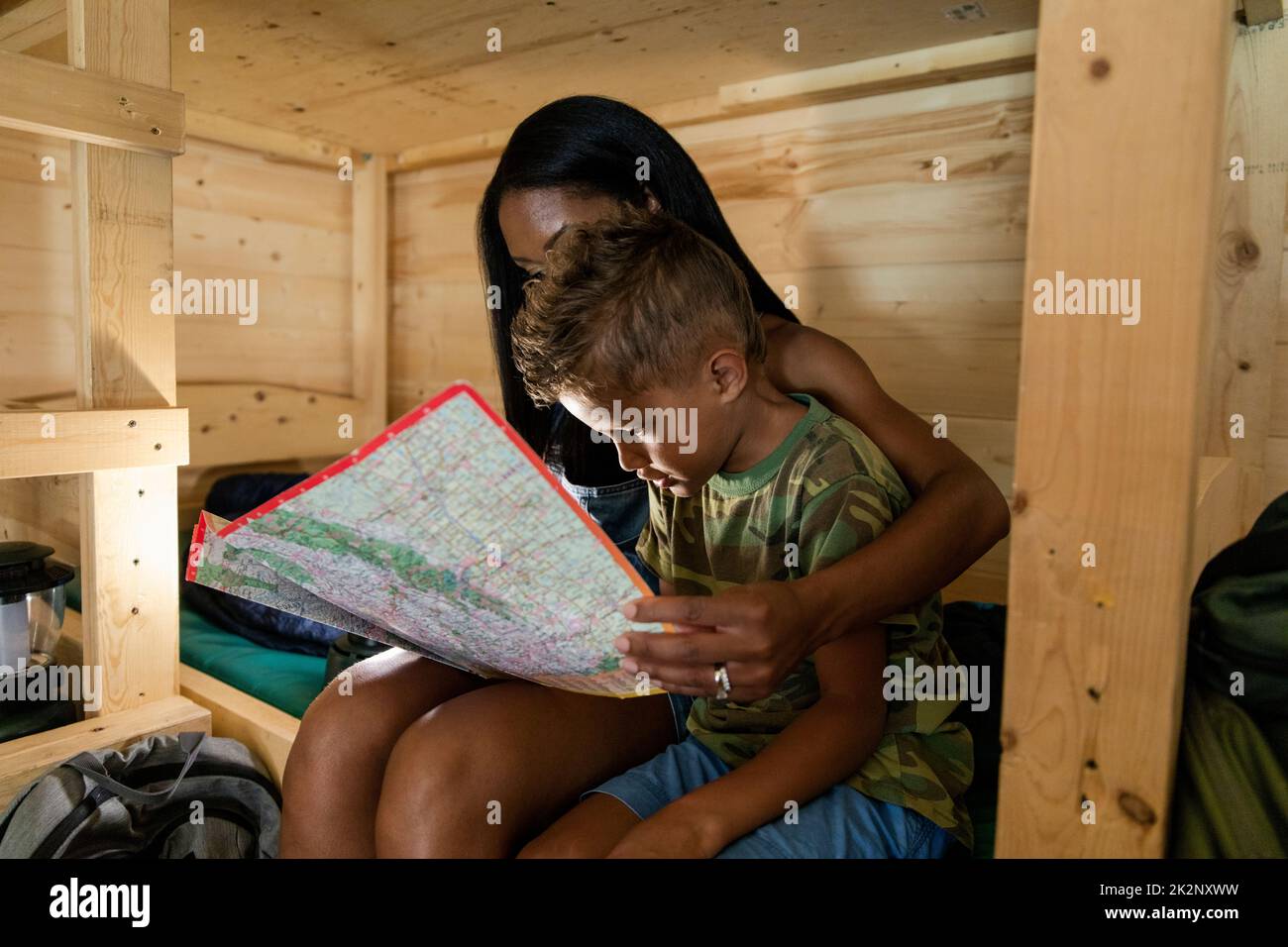 Mother And Son Reading Map In Cabin By Lamplight Stock Photo Alamy