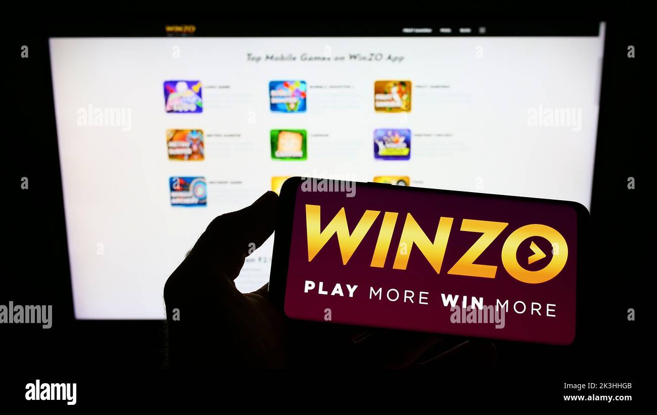 Person Holding Cellphone With Logo Of Indian Gaming Company WinZO Games