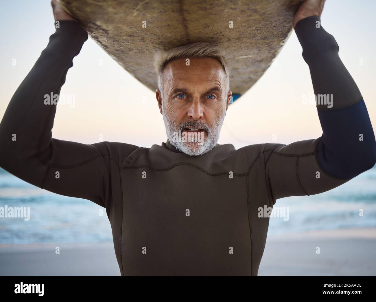 Beach Surf Board On Head And A Mature Surfer Man With Ocean Waves And