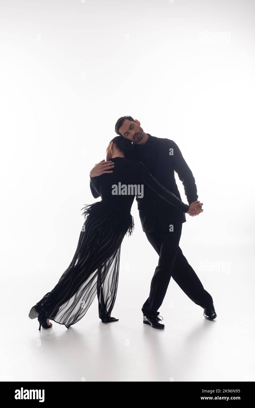 Ballroom Dancer Hugging Partner In Dress While Dancing Tango On White