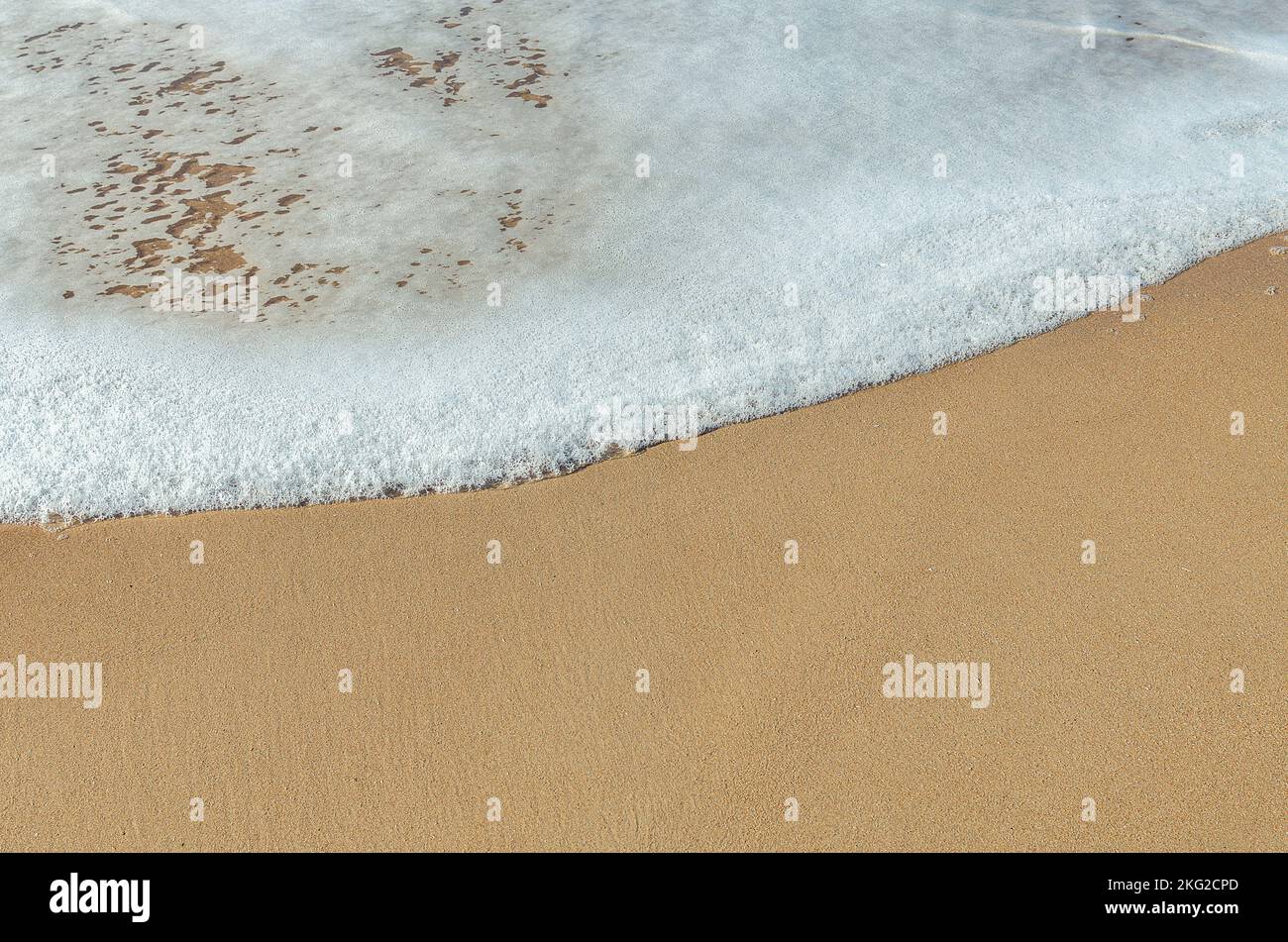 Close Up Of The White Foam Of A Wave On A Sandy Beach Top View Stock