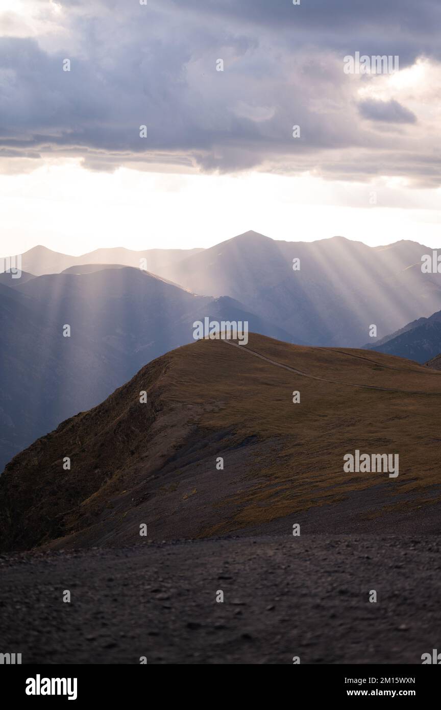 Scenic View Of Sun Rays Shining Through Clouds On Mountain Ridge