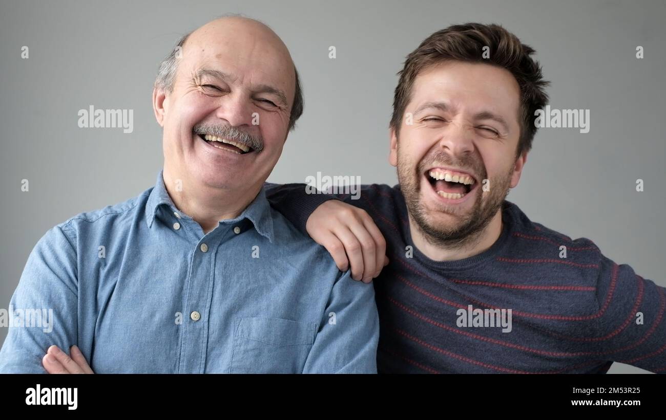 Happy Mature Senior Father And Grown Son Standing Together Hugging