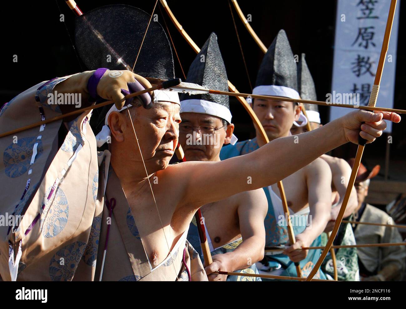 An Archer Dressed In A Traditional Japanese Warrior S Attire Prepares