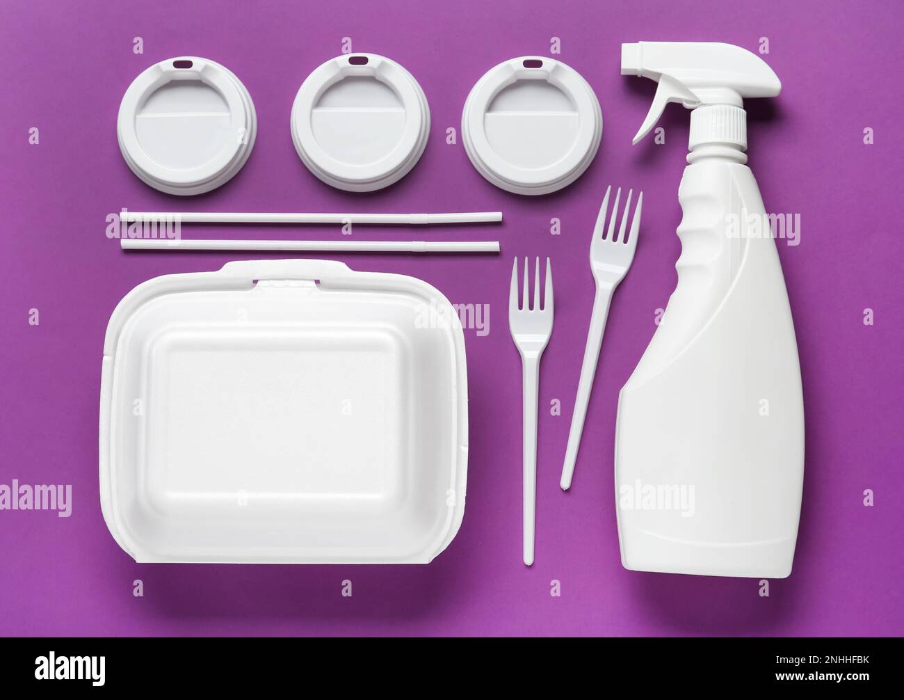 Plastic Dishware And Sprayer On Purple Background Flat Lay Stock Photo