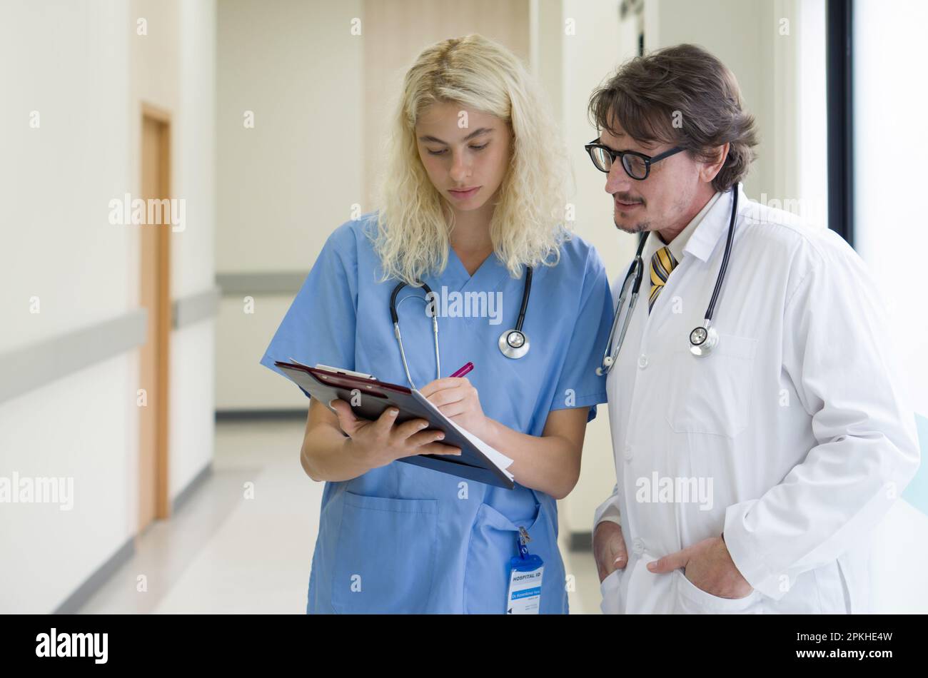 Senior Caucasian Doctor Having Discussion In A Hospital Hallway With