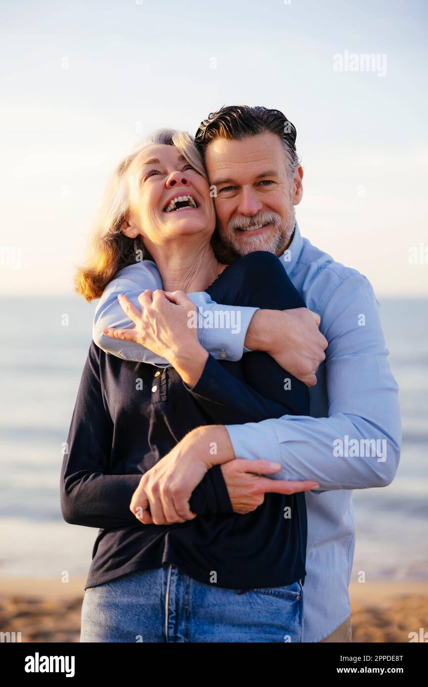 Happy Man Hugging Cheerful Mature Woman At Beach Stock Photo Alamy