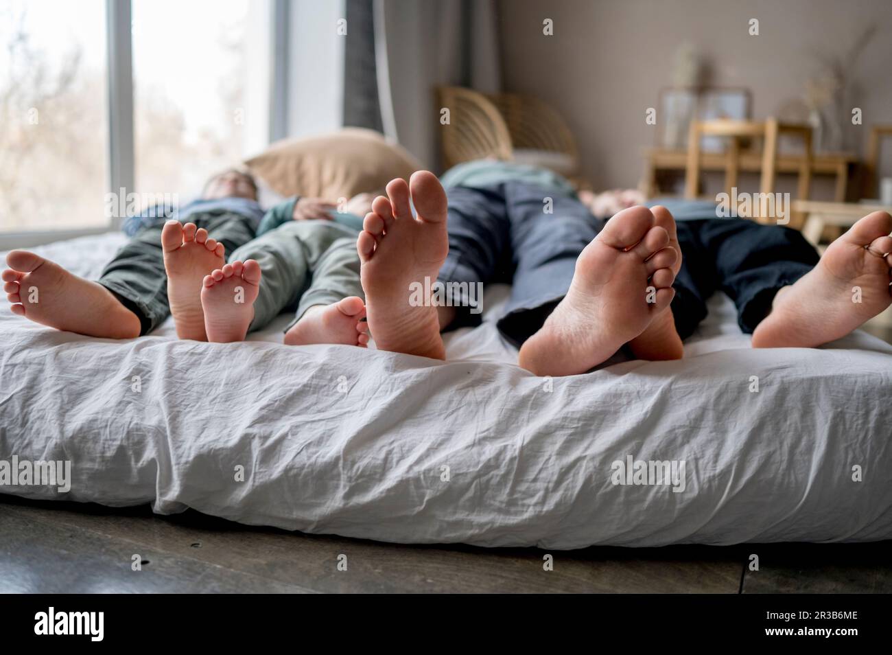 Father Sleeping With Sons On Bed At Home Stock Photo Alamy