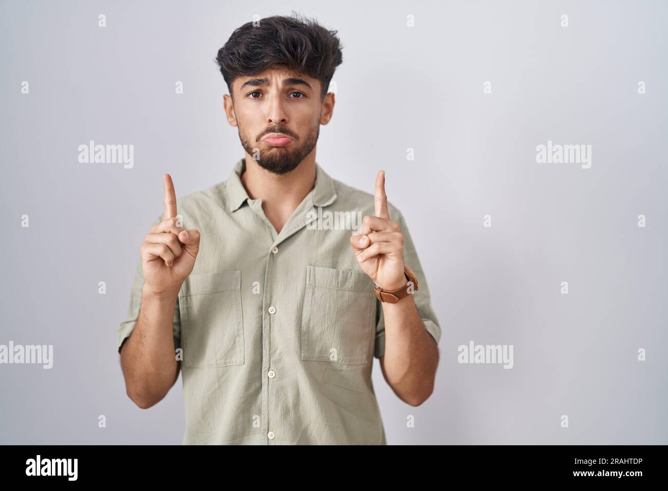 Arab Man With Beard Standing Over White Background Pointing Up Looking