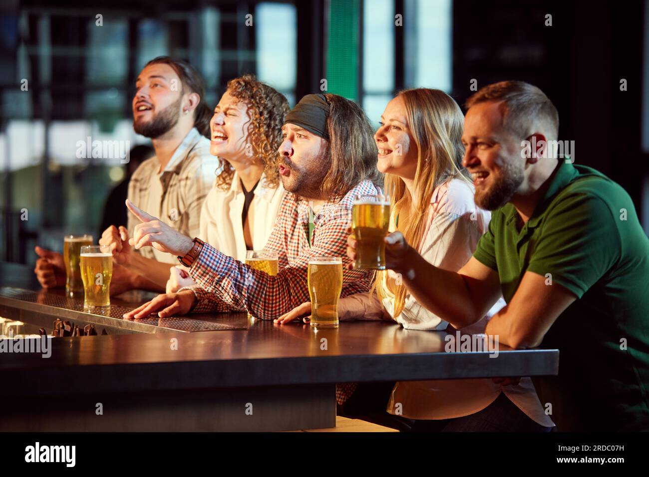 Cheerful People Friends Sitting In Bar Attentively Watching Football