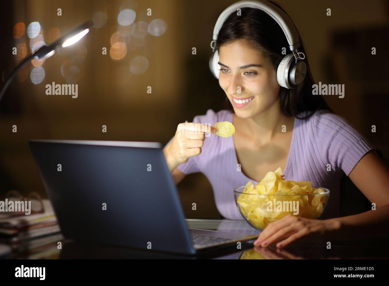 Happy Woman Wearing Headphone In The Night Watching Media On Laptop