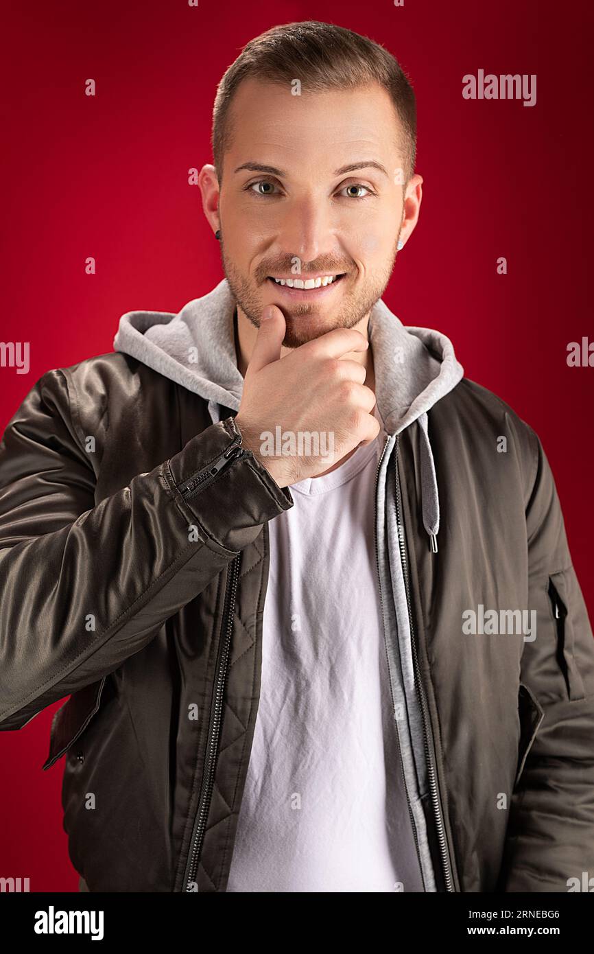 Modern Casual Guy Wearing Jacket And Standing In Front Of Red Wall