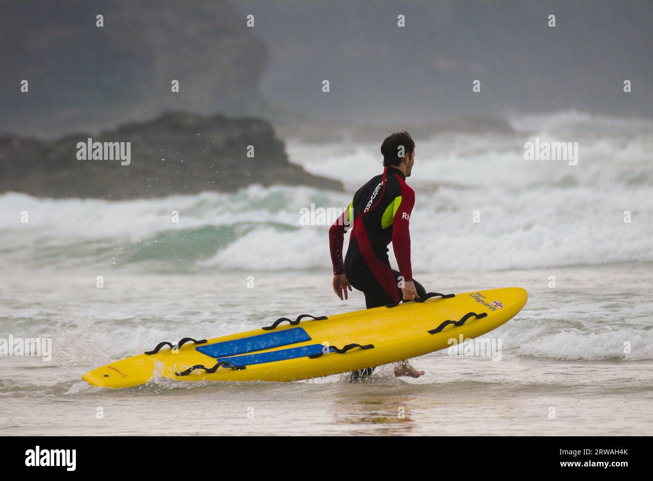 Rnli Lifeguard Member With Rescue Board Surfboard Heading Out To Rough