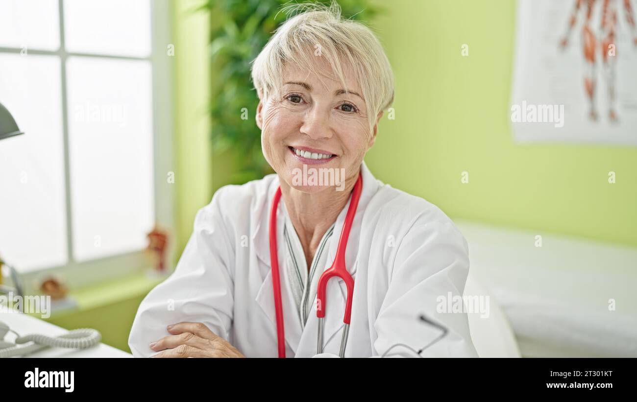 Middle Age Blonde Woman Doctor Smiling Confident Sitting With Arms