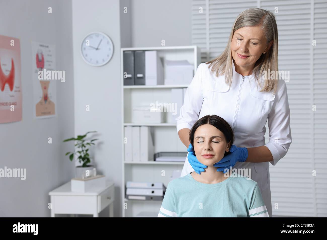 Endocrinologist Examining Thyroid Gland Of Patient At Hospital Stock