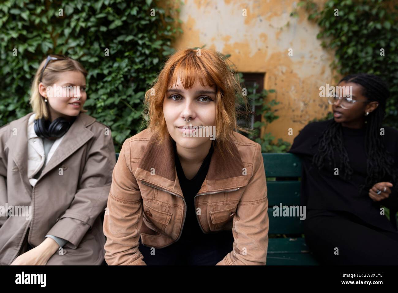 Portrait Of Blond Woman With Female Friends Talking While Sitting On