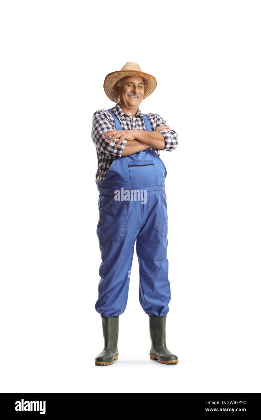Mature Farmer In Blue Overalls Wearing Gumboots And Straw Hat Isolated