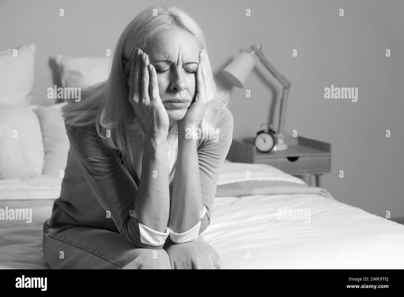 Depressed Mature Woman Sitting In Bedroom Stock Photo Alamy