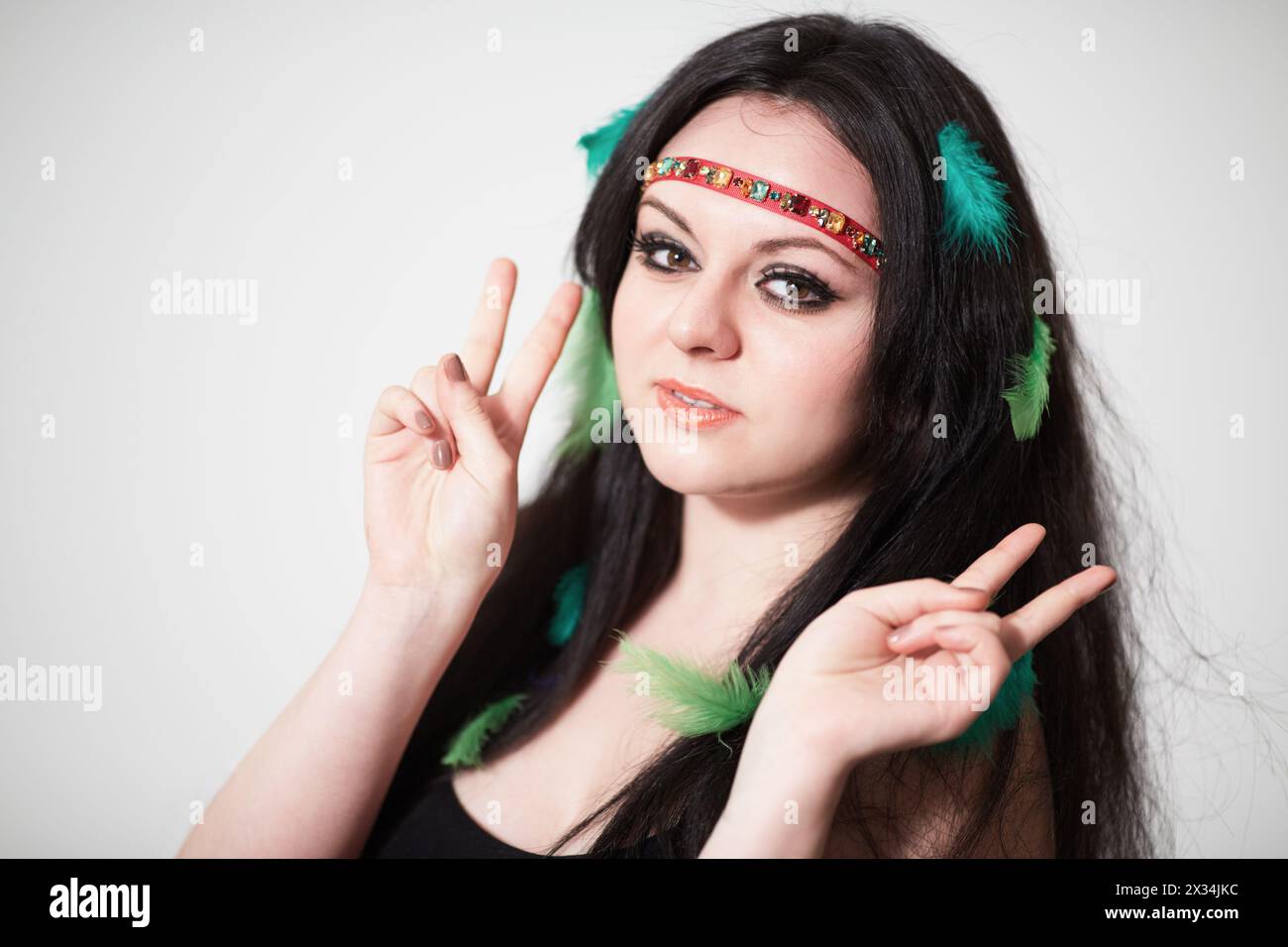 Smiling Dark Haired Girl Model With Feathers In Hair Shows V Both Hands