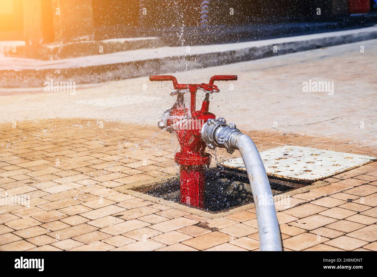 Red Fire Hydrant With Connected Hose With Splashing Water For