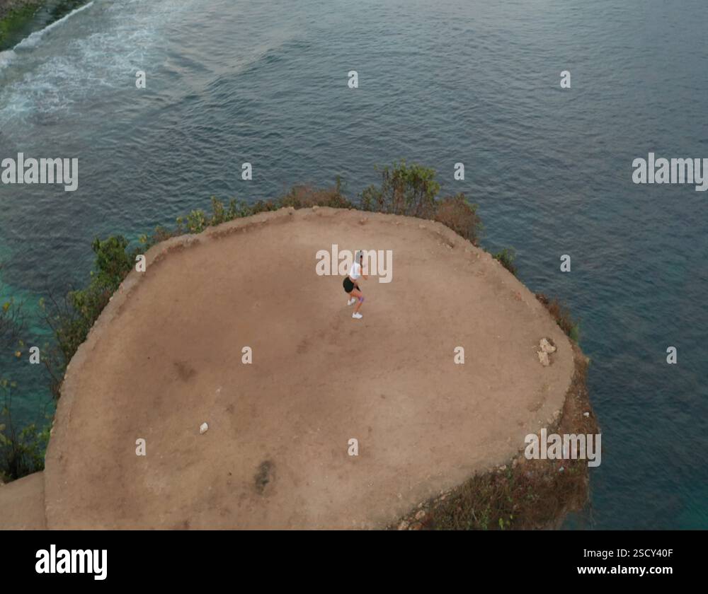 Aerial View Of Woman Exercising On Sea Shore Cliff At Sunrise Stock